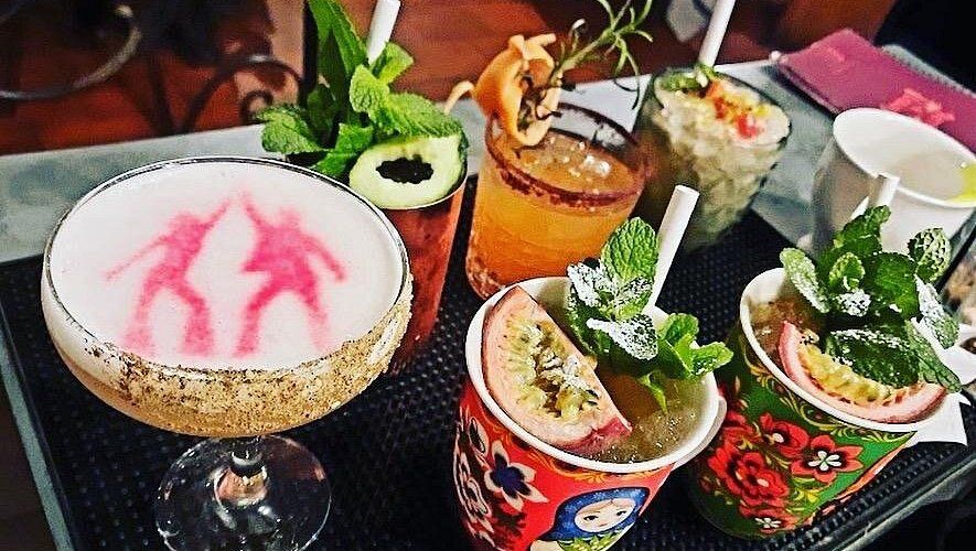 Un plateau de cocktails colorés, garnis de menthe et de fruits de la passion