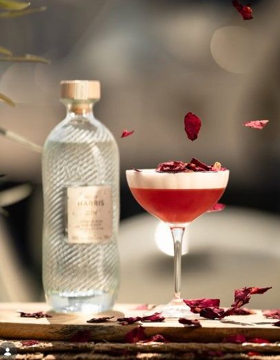 Le cocktail Cosmic Girl, rouge et mousseux, parsemé de pétales de rose
